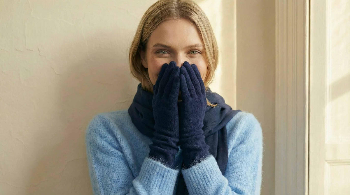 Woman wearing a blue sweater and dark gloves indoors.